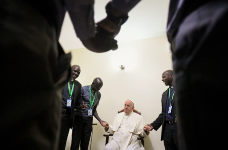 Papa Francisco sostiene sus manos con africanos